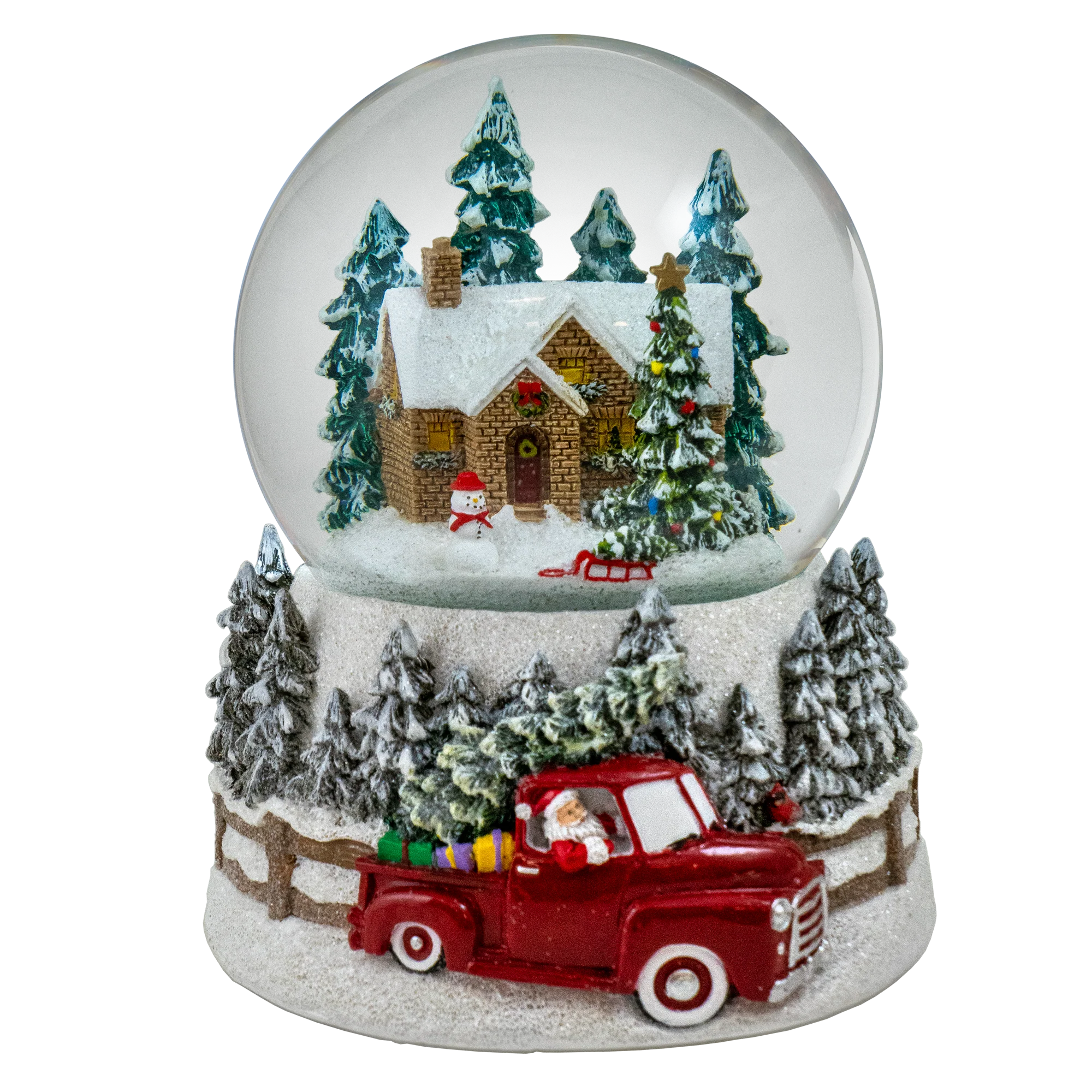 A festive Christmas snow globe figurine featuring a small snow-covered cabin, evergreen trees, a snowman, a red pickup truck carrying Santa, and a snowy base on a white background.