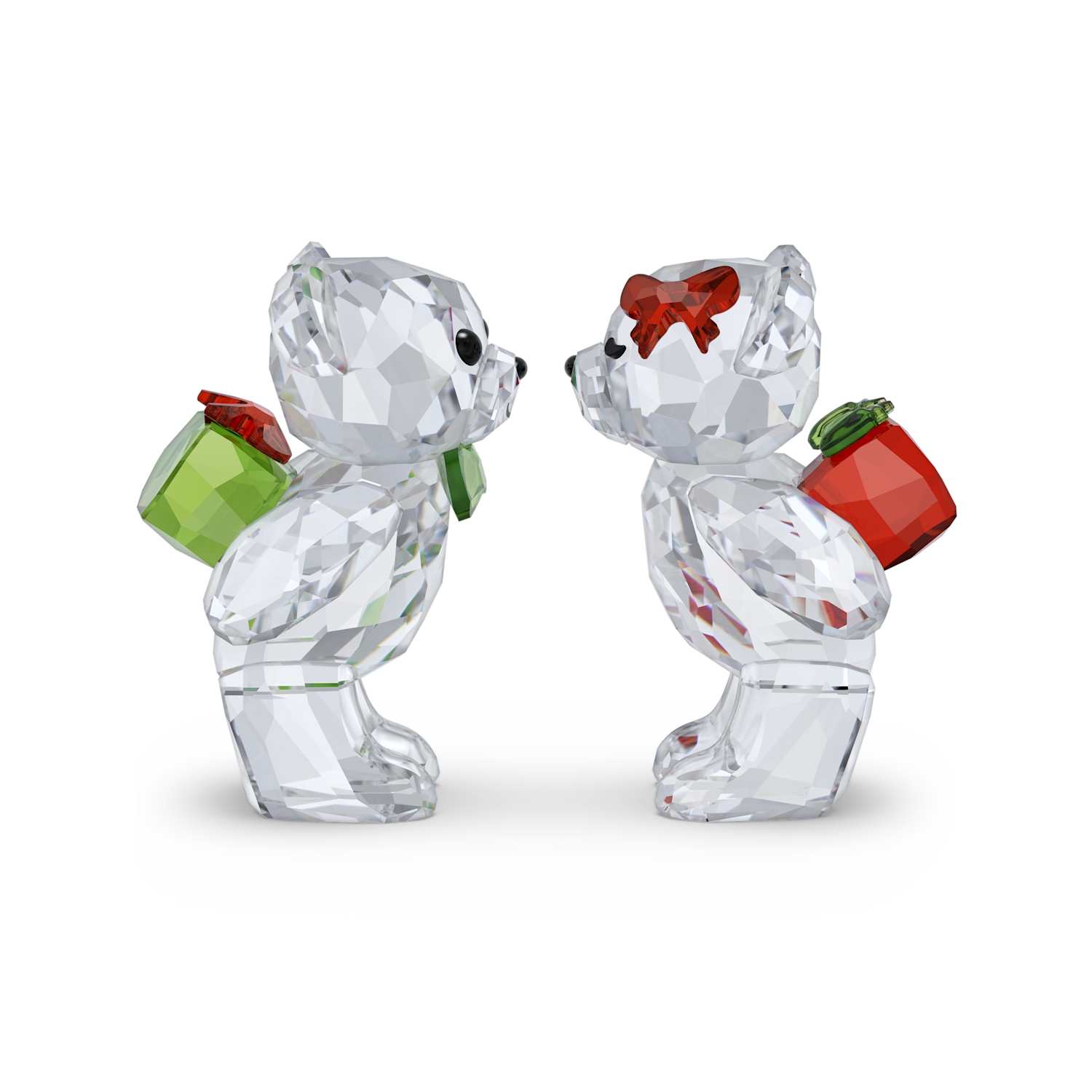 Two clear faceted crystal bear figurines facing each other on a white background. One bear wears a red bow and carries a green gift box, and the other carries a red gift box.