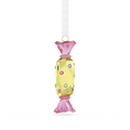 A hanging ornament shaped like a wrapped candy, made of faceted translucent pink and pale yellow material with small multicolored gem accents, suspended from a white ribbon on a plain white background.