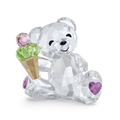 A faceted crystal teddy bear figurine holding an ice cream cone, with pink and green gemstone scoops, a gold cone, and purple heart accents on a white background.