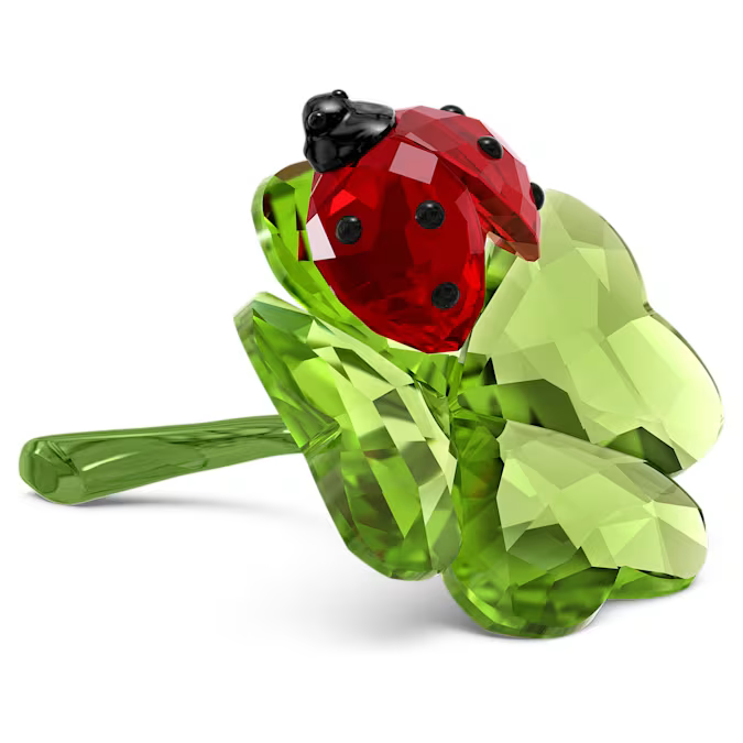 A crystal figurine by Swarovski featuring a red ladybug on a green clover, part of the Colored Nature Idyllia collection.